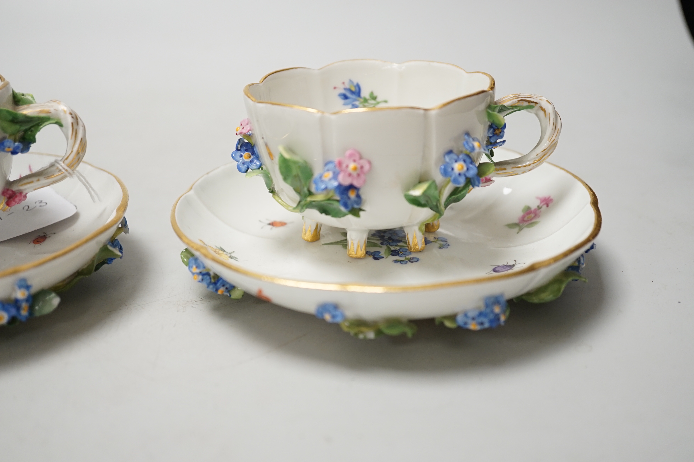 A pair of Meissen floral-encrusted cabinet cups and saucers, late 19th century, saucers 14cm diam.